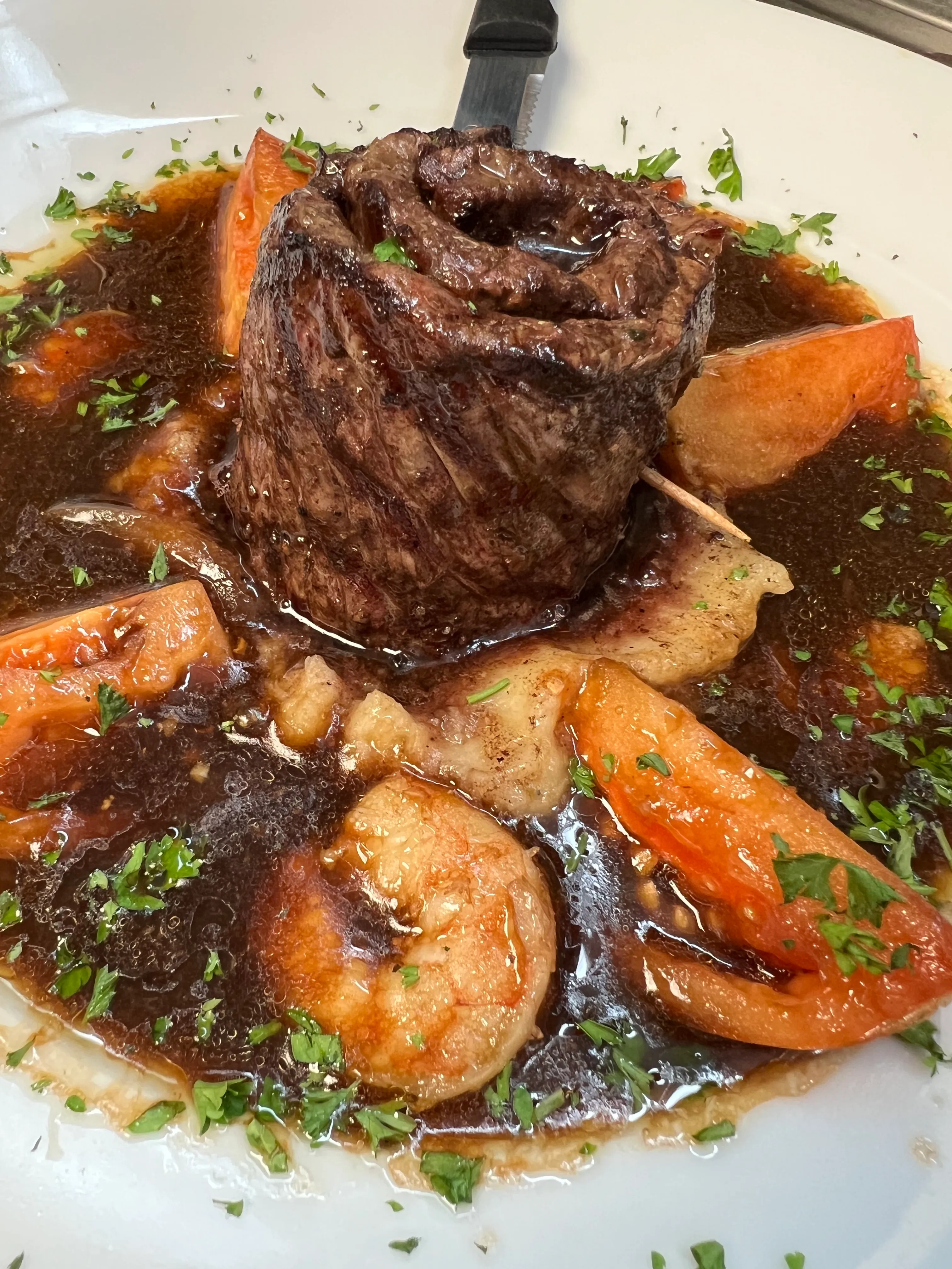 Bistec al estilo cubano en salsa de cebolla y tomate coronado con camarones salteados en Mojitos Calle 8, restaurante cubano en Miami
