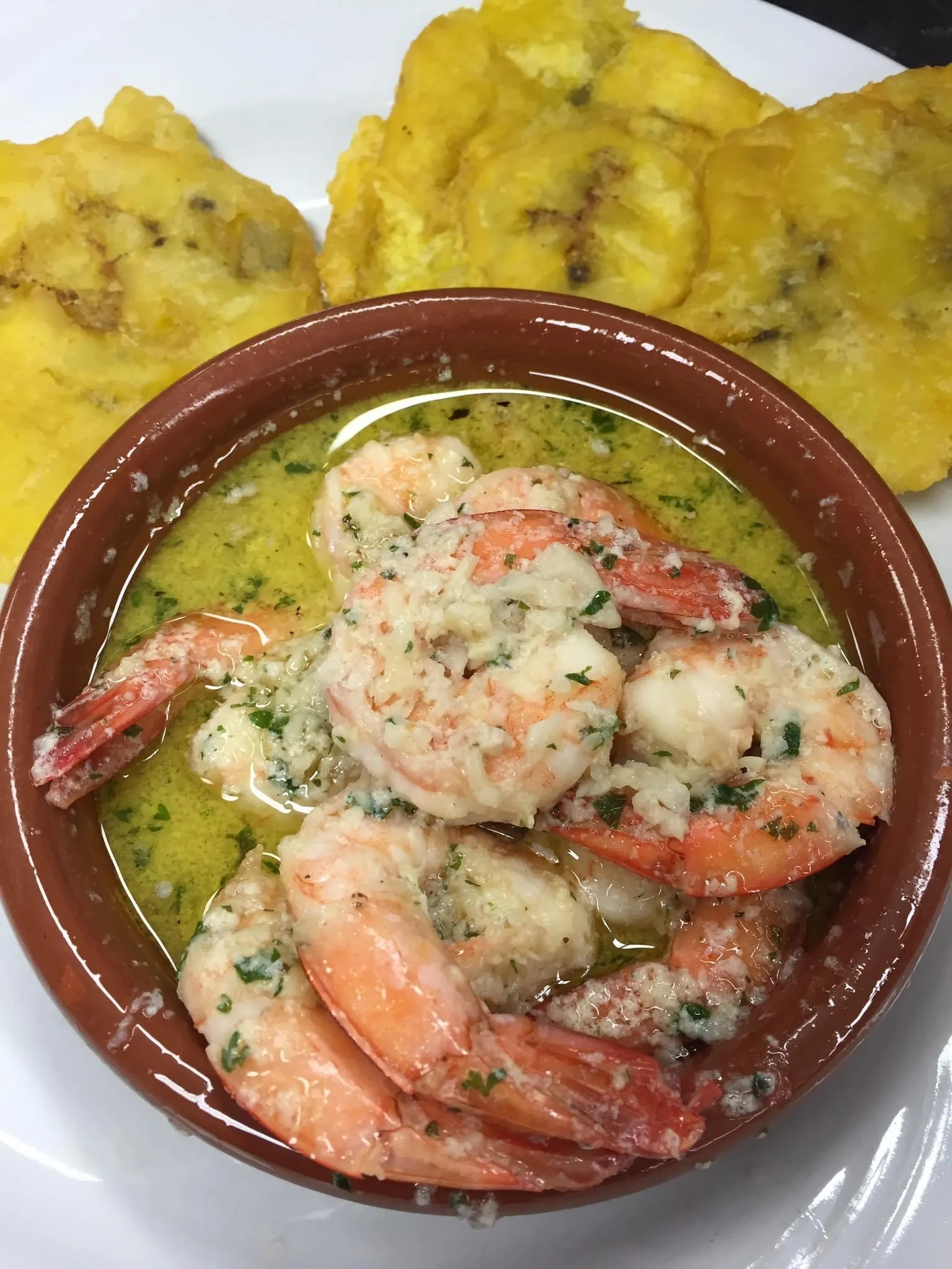 Camarones al ajillo cubanos en cazuela de barro con aceite de oliva y perejil, acompañados de tostones, en Mojitos Calle 8 en Miami
