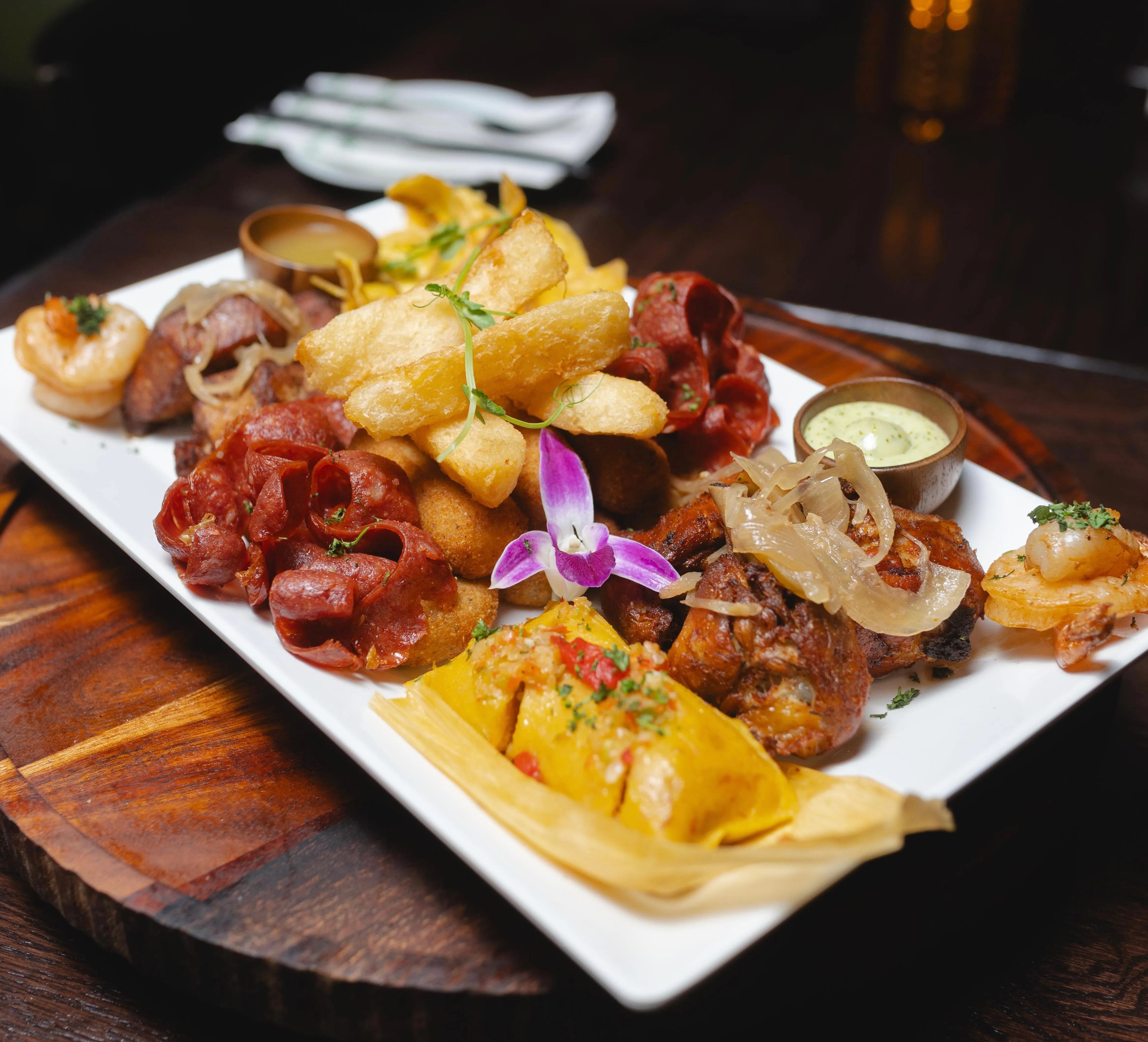 Picadera cubana con chorizo a la parrilla, croquetas de jamón, yuca frita, chicharrón de pollo con cebolla, camarones y un tamal en Mojitos Calle 8 en Miami