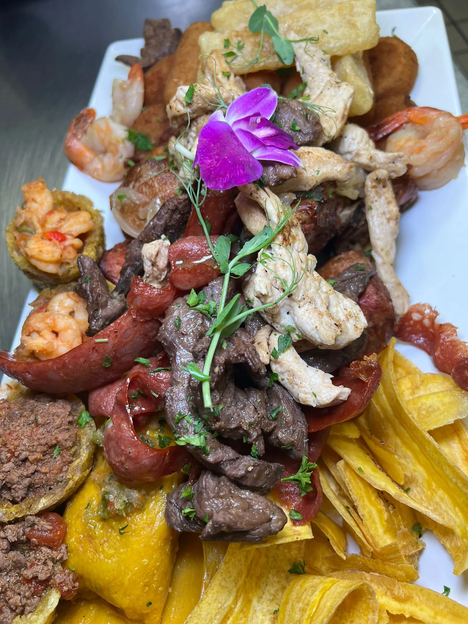 Gran plato de picadera cubana con tiras de bistec a la parrilla, pollo, chorizo, camarones, yuca frita, tostones rellenos y mariquitas de plátano en Mojitos Calle 8, restaurante cubano en Miami